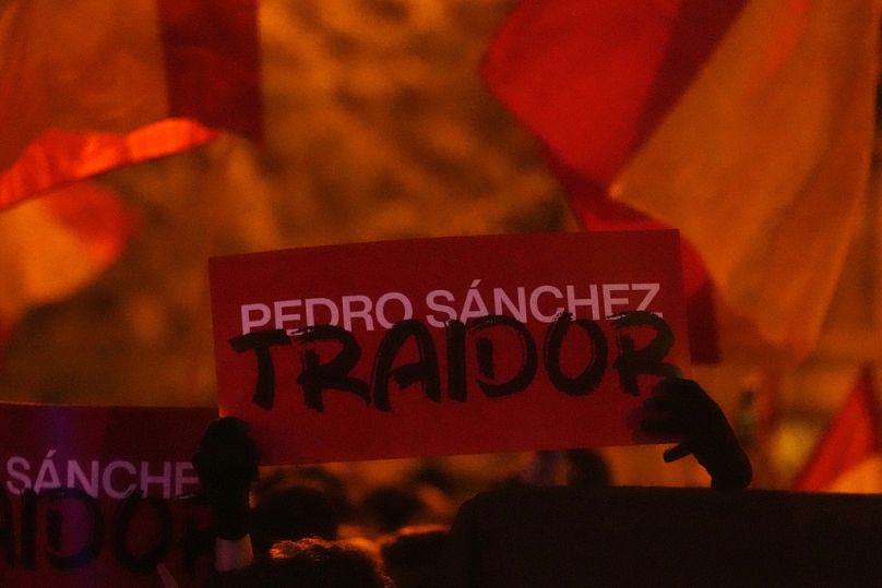 A sign reading 'Pedro Sanchez, Traitor' is held up during a protest by right wing demonstrators near the national headquarters of Spain's Socialist Party in Madrid.