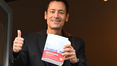 Laureate of the Prix Goncourt literary prize, French author Jean-Baptiste Andrea poses with his book during the award ceremony at Drouant restaurant, in Paris