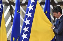 A member of protocol adjusts the Bosnia- Herzegovina flag prior to arrivals at an EU summit in Brussels, Thursday, June 23, 2022. 