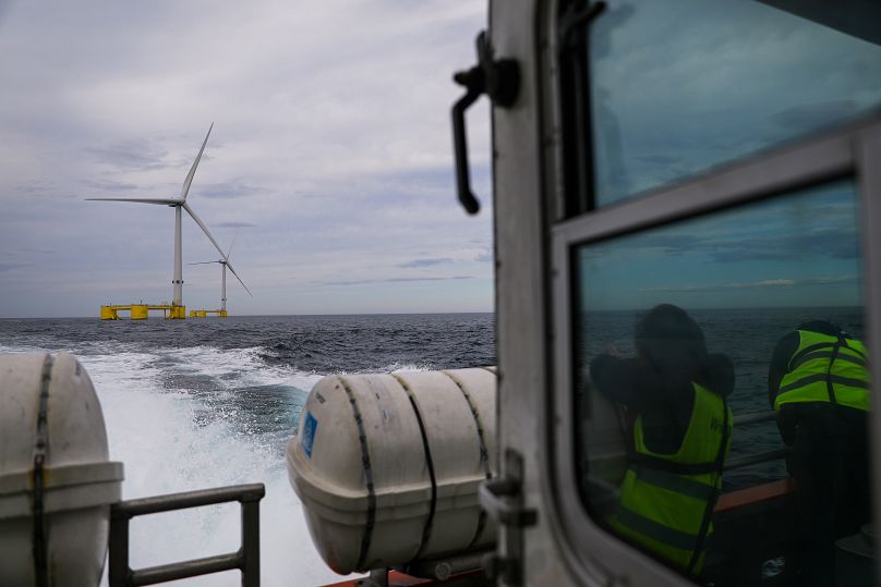 Visitors in a boat observe the turbines of the WindFloat Atlantic Project, a floating offshore wind-power generating platform, 20 kilometers off the coast in Viana do Castelo.