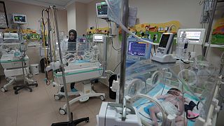 طاقم طبي يعالج طفلًا في مستشفى الأقصى في دير البلح بقطاع غزة. 