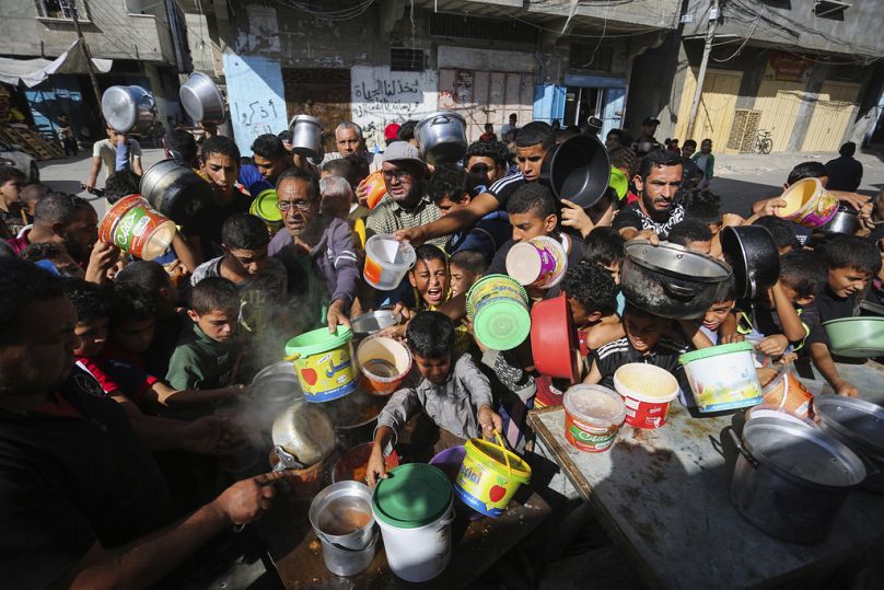 Palestinesi in attesa della distribuzione di cibo a Rafah, nel sud della Striscia di Gaza, 8 novembre 2023