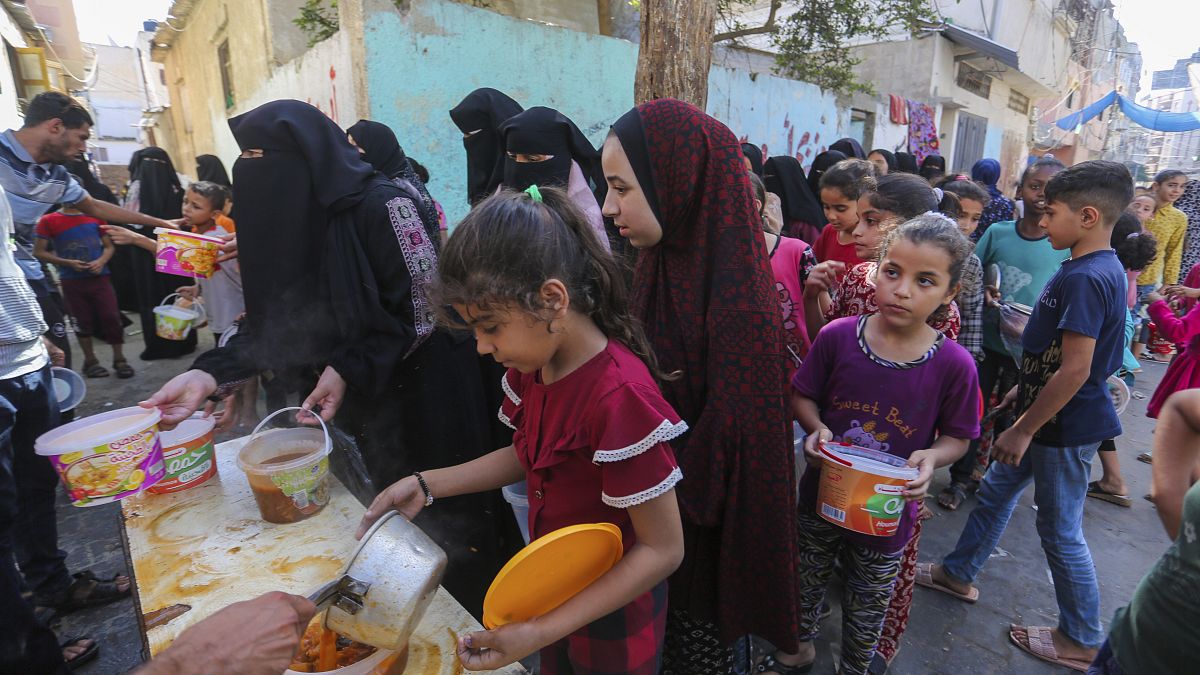Палестинцы стоят в очереди за едой в Рафахе. 