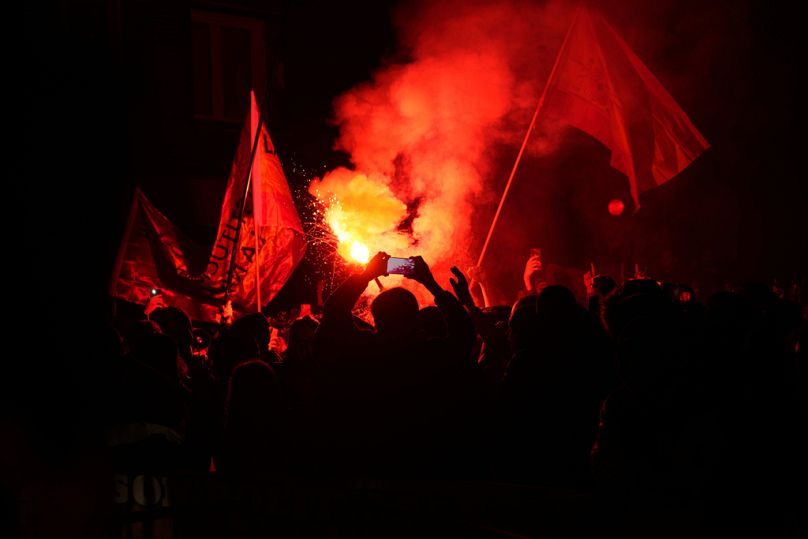Flares are lit during a protest by right wing demonstrators near the national headquarters of Spain's Socialist Party in Madrid, Spain