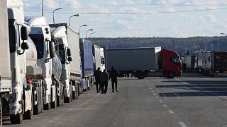Truck drivers walk on the road past queue of trucks in the Lviv Oblast, Ukraine. 