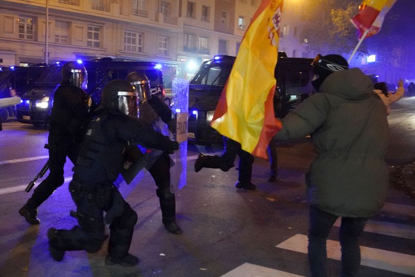 Polizia spagnola cerca di disperdere i manifestanti durante una protesta contro l'amnistia presso la sede del partito socialista a Madrid, Spagna, 9 novembre 2023
