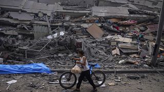 Палестинский ребенок на фоне разрушенного здания в городе Газе. 8 октября 2023 года