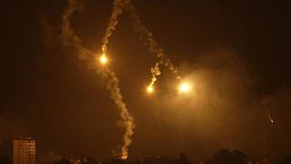 Wide shot huge fireballs erupt in northern Gaza seen from Israel.