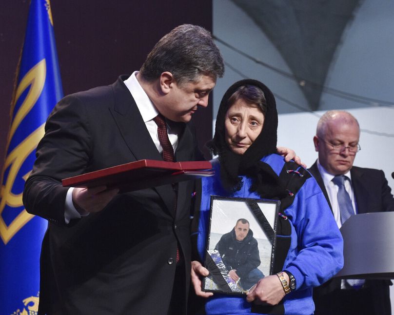 Ukrainian President Poroshenko presents a Hero of Ukraine award to a relative of an activist killed in the mass protests during a ceremony in Kyiv, 20 Feb, 2015.