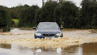 Un coche atraviesa una carretera inundada en Francia.