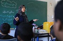 Una profesora da clase en una escuela refugio de la ranja de Gaza