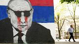 FILE - A man passes by a mural depicting the Russian President Vladimir Putin vandalized with paint, in Belgrade, Serbia, Saturday, May 7, 2022.
