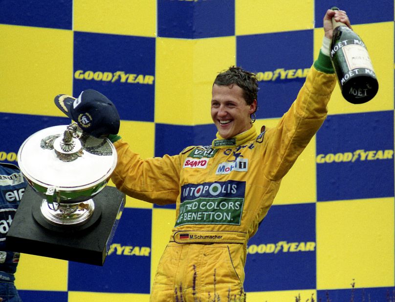 Michael Schumacher is all smiles, holding the trophy and the magnum bottle of champagne, after winning his first Grand Prix race in Francorchamps, Belgium, August 30, 1992,