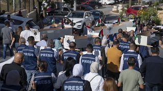 صحفيون فلسطينيون خلال جنازة رمزية أمام مكتب الأمم المتحدة في مدينة رام الله بالضفة الغربية.