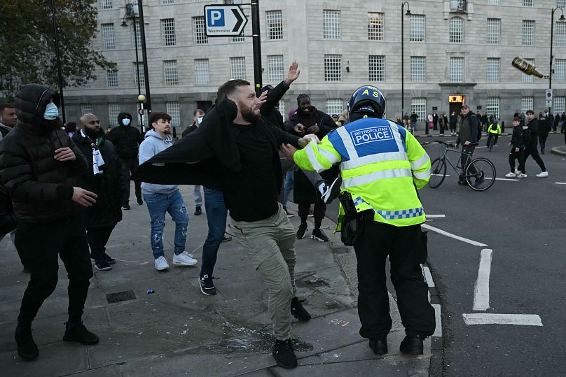 Сотрудник полиции разделяет участников "Марша за Палестину" и крайне правых в центре Лондона, 11 ноября 2023 г.