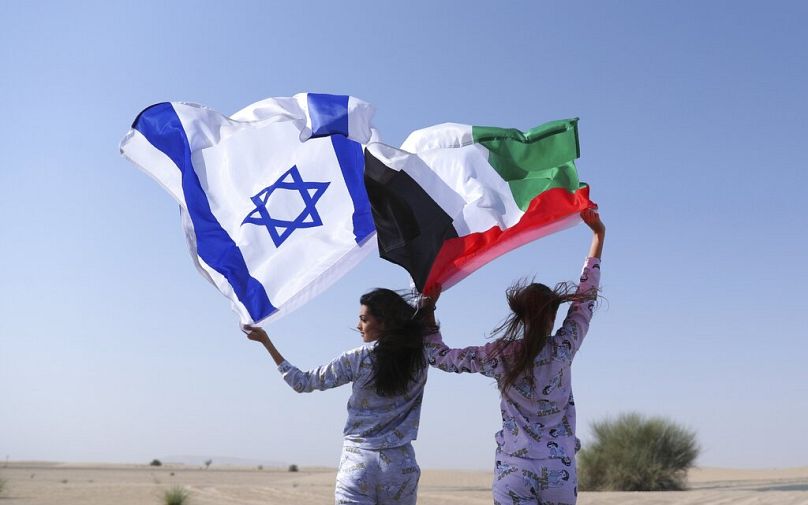 İsrail (sol) ve BAE bayraklarını tutan modeller (arşiv)