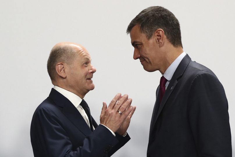 Канцлер Германии Олаф Шольц (слева) беседует с исполняющим обязанности премьер-министра Испании Педро Санчесом