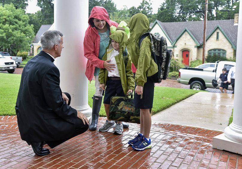 The Rev. Joseph Strickland, left, bishop of the Diocese of Tyler, goes to one knee Wednesday, Aug. 17, 2016, Tyler, Texas