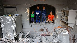 Children look on inside a damaged building following strikes on Rafah in the southern Gaza Strip on Sunday