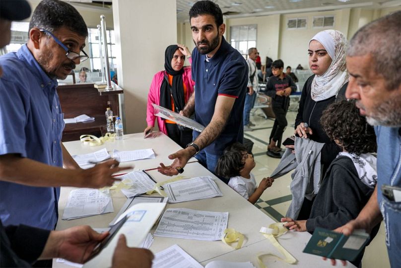 People present their travel documents to be checked at the terminal on the Palestinian side of the Rafah border crossing with Egypt in the southern Gaza Strip on Sunday