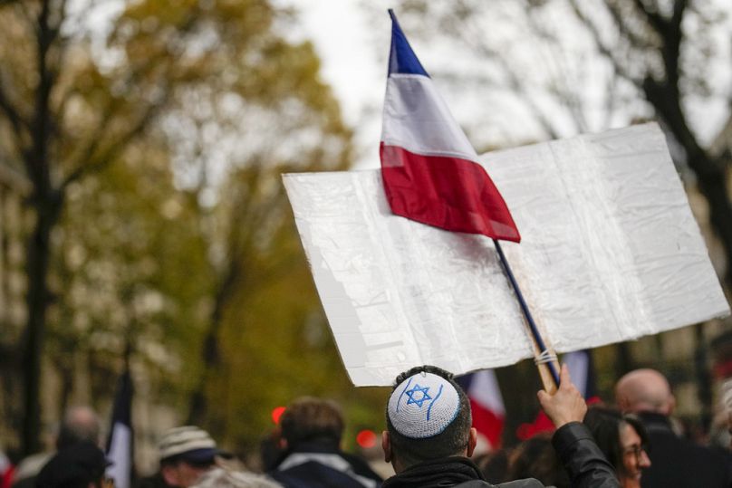 Başında kipa ve elinde Fransız bayrağı bulunan bir gösterici