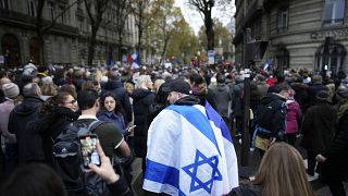 Un manifestante con una bandera israelí se une a miles de personas en una marcha contra el antisemitismo en París, Francia, el domingo 12 de noviembre de 2023.