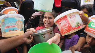 Palestinians line up for food during the ongoing Israeli bombardment of the Gaza Strip in Rafah on Monday, November 13, 2023. 