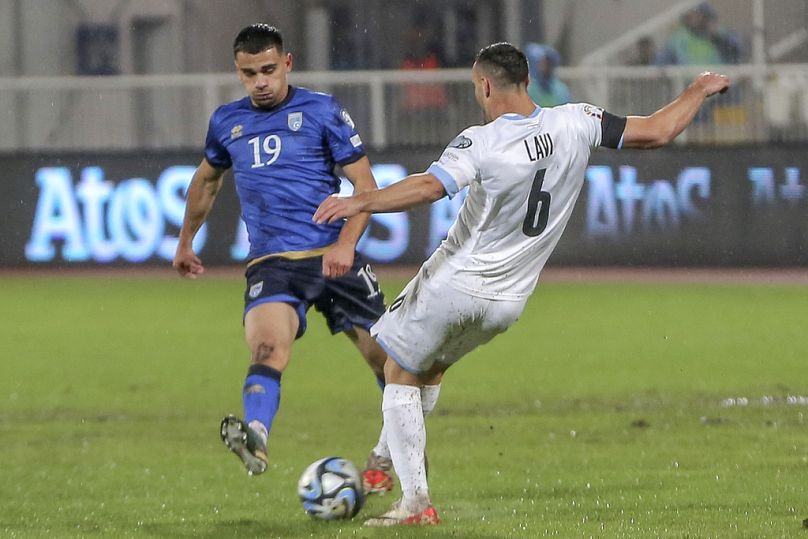 Israel's Neta Lavi, right, and Kosovo's Florian Loshaj, left, challenge for the ball during the Euro 2024 group I qualifying soccer match between Kosovo and Israel