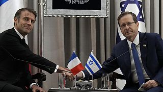 الرئيس الفرنسي إيمانويل ماكرون، على اليسار، يصافح الرئيس الإسرائيلي إسحاق هرتسو�� في القدس، 24 أكتوبر، 2023.