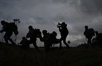 A journalist runs with Ukrainian infantrymen during a training with French soldiers, in France, Tuesday, Nov. 7, 2023.