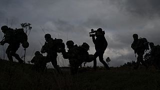 A journalist runs with Ukrainian infantrymen during a training with French soldiers, in France, Tuesday, Nov. 7, 2023.
