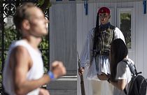 Un soldado de la guardia presidencial observa el paso de un corredor participante en la 40ª edición del denominado 'Maratón Auténtico de Atenas', en Grecia.