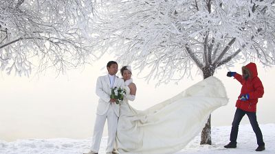 يلتقط زوجان صور زفاف بجانب الأشجار المغطاة بالجير على طول نهر سونغهوا في مدينة جيلين، مقاطعة جيلين شمال شرق الصين، يوم الاثنين 3 يناير 2011.