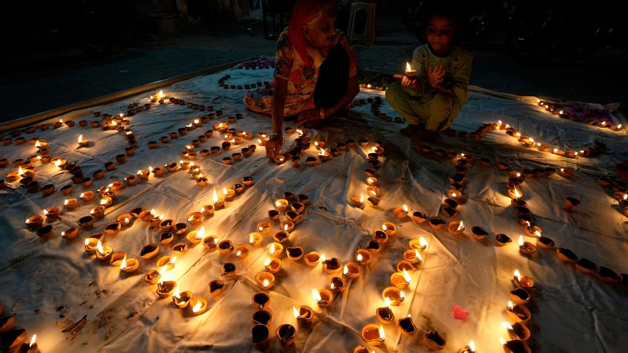 A Hindu woman, left, attends a ceremony to celebrate Diwali, the festival of lights, at Somi Narin temple in Karachi, Pakistan, Sunday, Nov. 12, 2023.