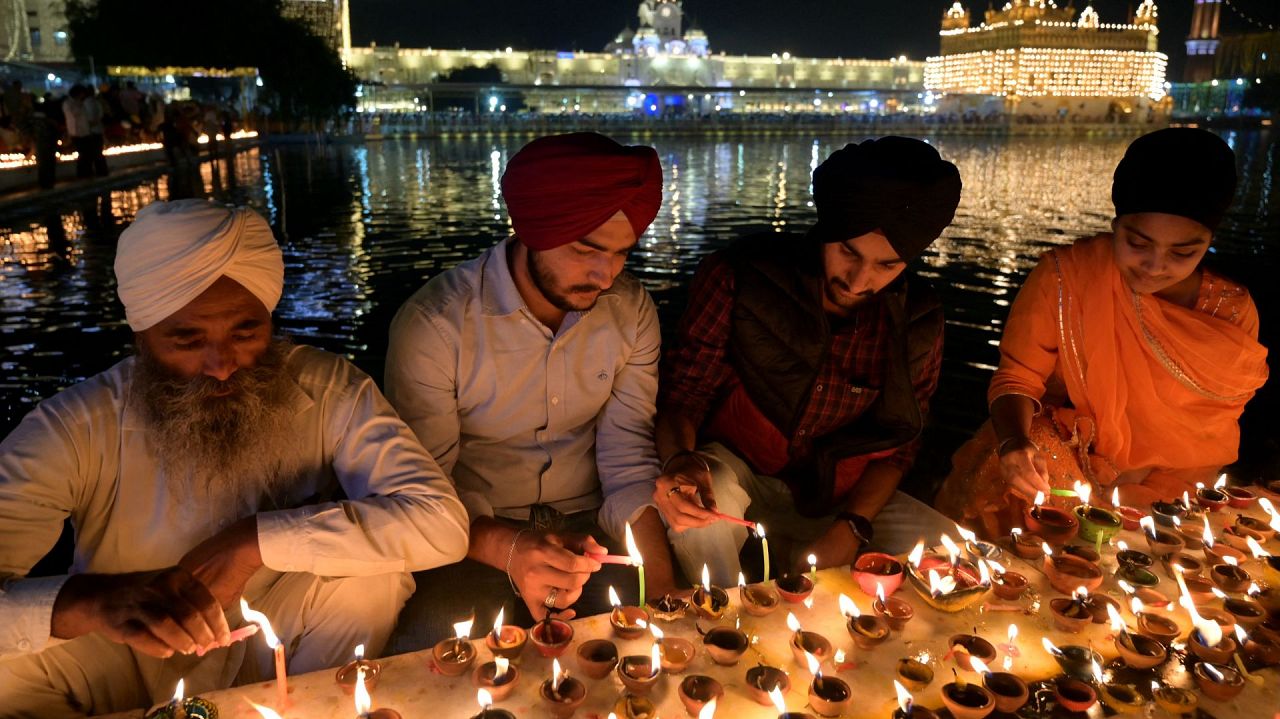 Sikh devotees light oil lamps on the occasion of the Sikh festival Bandi Chhor Divas or Diwali festival at the illuminated Golden Temple in Amritsar on November 12, 2023.