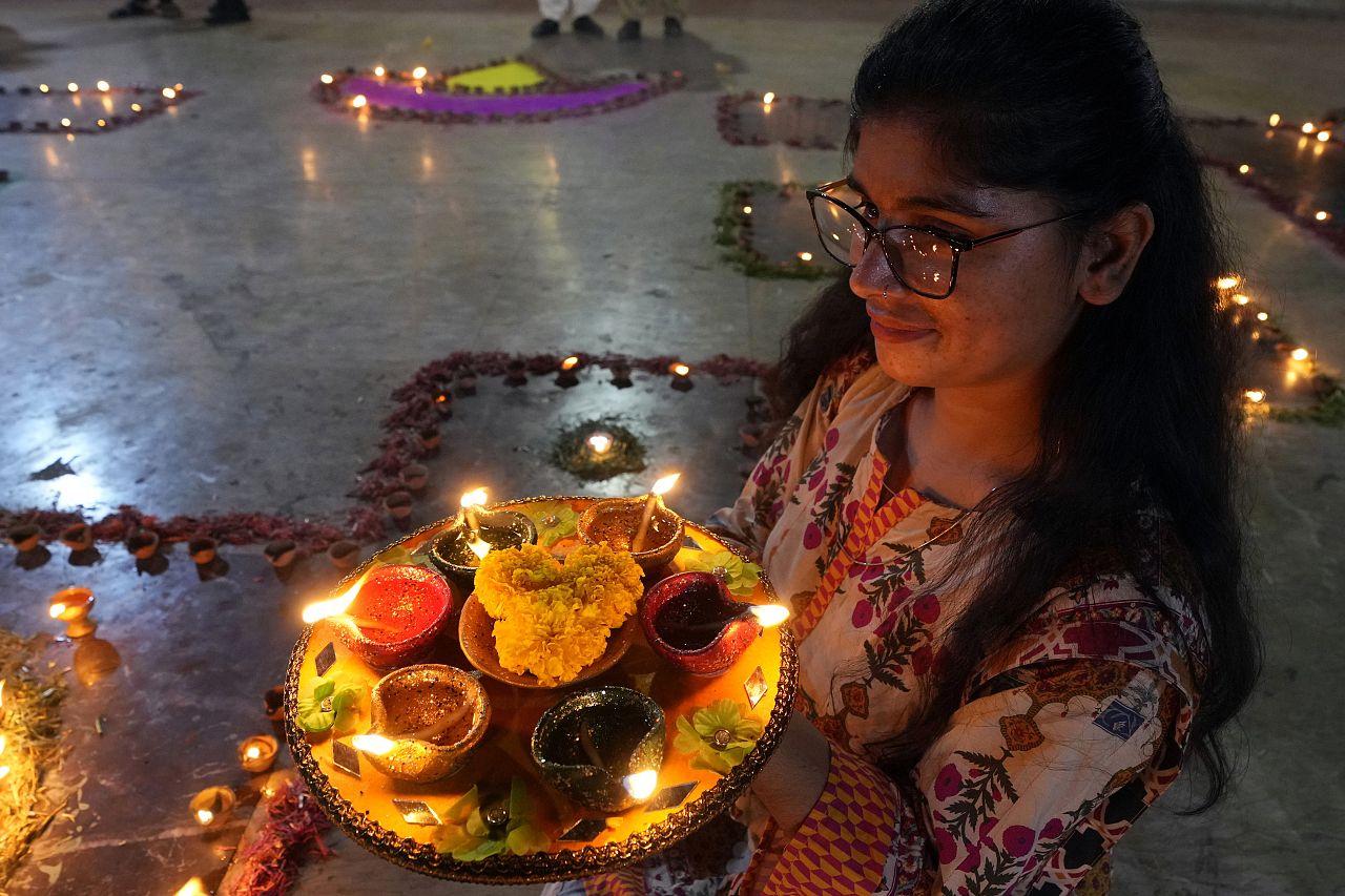 A Hindu woman hold clay-lamp during a ceremony to celebrate Diwali, the festival of lights, at Somi Narin temple in Karachi, Pakistan, Sunday, Nov. 12, 2023.
