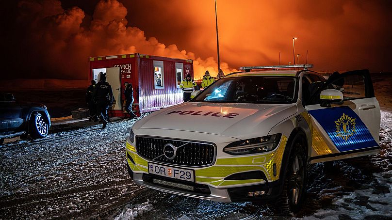 A police vehicle is parked at the entrance of the road to Grindavík with the eruption in the background, near Grindavik on Iceland's Reykjanes Peninsula, 18 December 2023.