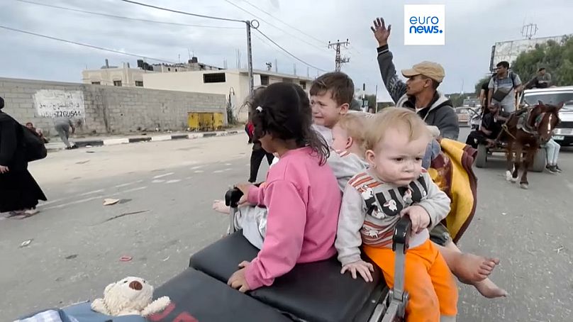 Niños que huyen hacia el sur de la Franja de Gaza, transportados en una camilla de hospital