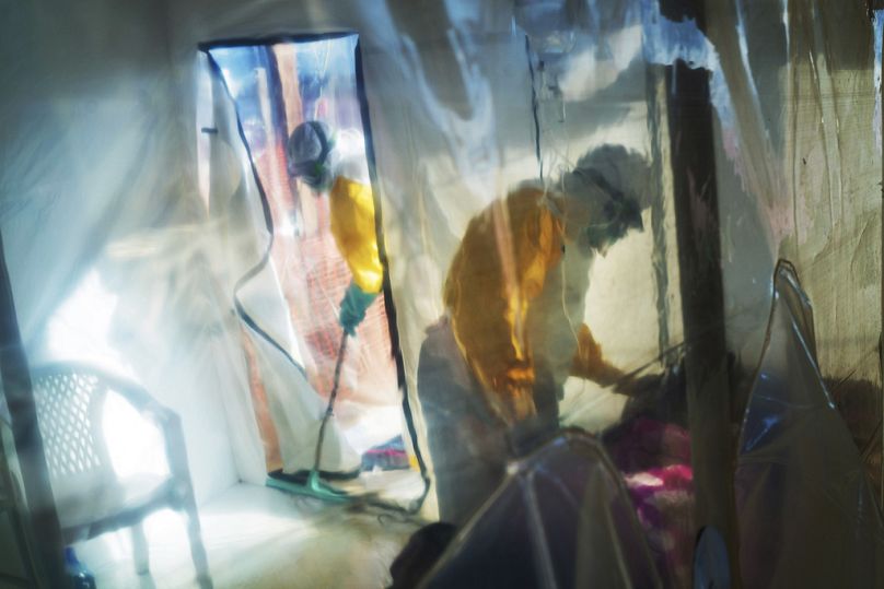 Health workers wearing protective suits tend to to an Ebola victim kept in an isolation tent in Beni, Democratic Republic of Congo, on Saturday, July 13, 2019.