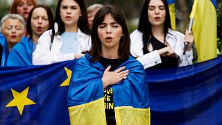 Женщины поют, завернувшись в флаг Украины