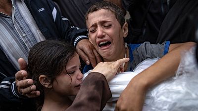 Crianças palestinianas choram a morte de familiares em Khan Younis, na Faixa de Gaza