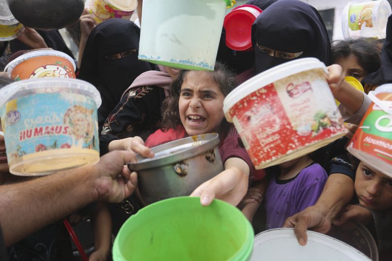 İsrail saldırıları nedeniyle evlerinden kaçmak zorunda kalan Filistinliler, BM kamplarında yemek alabilmek için mücadele ederken