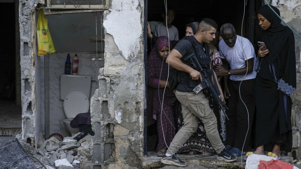 Palestiniano caminha sobre escombros de edifício, na cidade de Tulkarem, Cisjordânia, após ataque israelita
