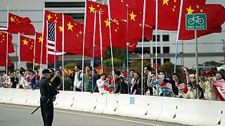 Con banderas estadounidenses y chinas ondeando, la gente observa el paso de la caravana del presidente Joe Biden el martes 14 de noviembre de 2023, en San Francisco