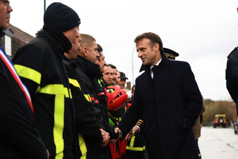 President Emmanuel Macron shakes hands with members of rescue teams in Blendecques, northern France on Tuesday