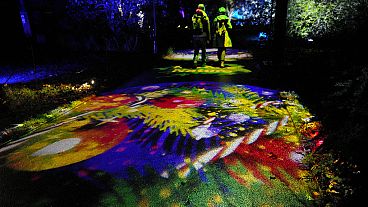 People walk through the festive light trail at The Royal Botanic Gardens, Kew, in London, Tuesday, Nov. 14, 2023.