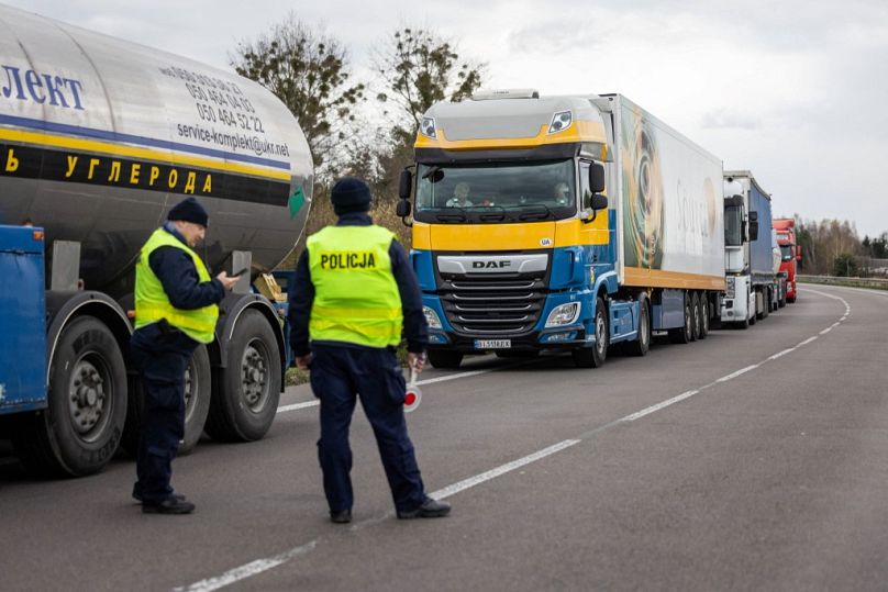 Polish police officers are seen next to a queue of trucks as transport company owners block access to the Polish-Ukrainian border crossing in Dorohusk, Poland on November 6.