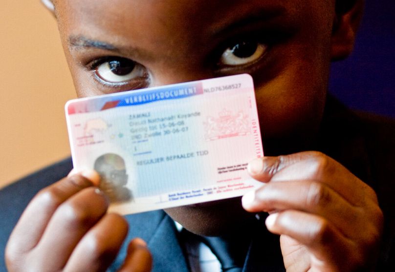 A man shows his new residency permit in Den Bosch, July 2007