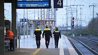 Personal de seguridad camina por un andén vacío en la estación principal de Essen, Alemania, este jueves 16 de noviembre