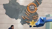 A man passes by a map depicting Evergrande's commercial projects in China at a mall in Beijing, China on Dec. 7, 2021.